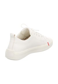 Witte leren sneaker met een gestructureerde rubberen zool, ronde neus, vetersluiting aan de voorkant en een subtiele rode accent nabij de hak. Glad oppervlak en minimalistisch ontwerp.