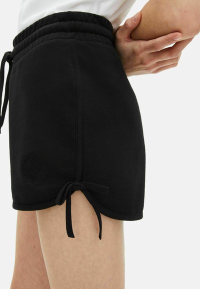 Zwarte katoenen shorts met een elastische tailleband, zijknooptouwen en een klein reliëf logo detail nabij de zoom, met een zachte textuur.