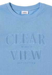 Sweatshirt bleu clair avec un col rond, arborant un texte brodé "REFLEXION DE LA VUE D'UNE ESPRIT CLAIR" dans une teinte légèrement plus sombre.