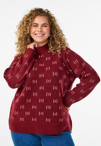 Maglione a punto di maglia bordeaux con collo alto, caratterizzato da un motivo testurizzato di linee verticali in bianco, vestibilità morbida e polsini e orlo a coste.