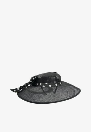 Széles karimájú fekete hálós kalap fekete-fehér pöttyös szalaggal és az oldalán megkötött masnival.
