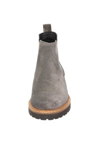 Bottine en suède gris avec bout arrondi, tige courte et semelle en caoutchouc plate présentant un motif texturé et des coutures contrastées.