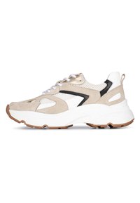 Beige suede en mesh sneaker met witte en zwarte accenten, voorzien van een dikke witte zool en vetersluiting. Rubberen buitenzool voor grip.