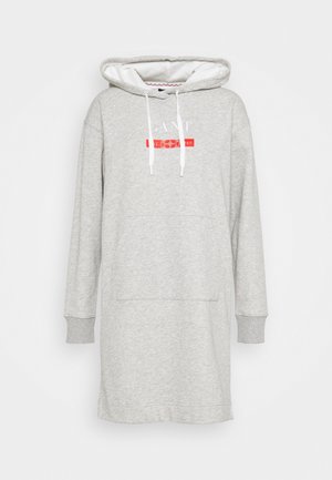 Grauer Kapuzenpullover-Kleid mit einer Fronttasche, schlanken weißen Kordeln und einem grafischen Druck in Rot und Weiß auf der Brust. Weiche Stoffstruktur.