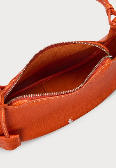 Orange usnjena torbica z teksturiranim zaključkom, z zgornjim delom z zadrgo in gladko, kontrastno notranjo podlogo. Minimalističen logotip.