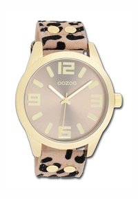 Round gold watch with a brown gradient face, featuring large hour markers. Soft beige strap with black leopard print and metal accents.