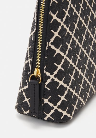 Black and cream patterned bag featuring a textured surface, gold zipper hardware, and a structured shape with a tapered design.