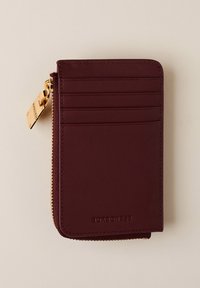 Burgundy leather wallet with gold zipper, multiple card slots, and embossed brand name. Smooth texture and rectangular shape.