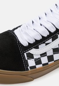 Fekete-fehér kockás vászon sneaker velúr részletekkel, fehér fűzőkkel és gumi talppal. Kontrasztos varrásokkal és oldal logóval rendelkezik.