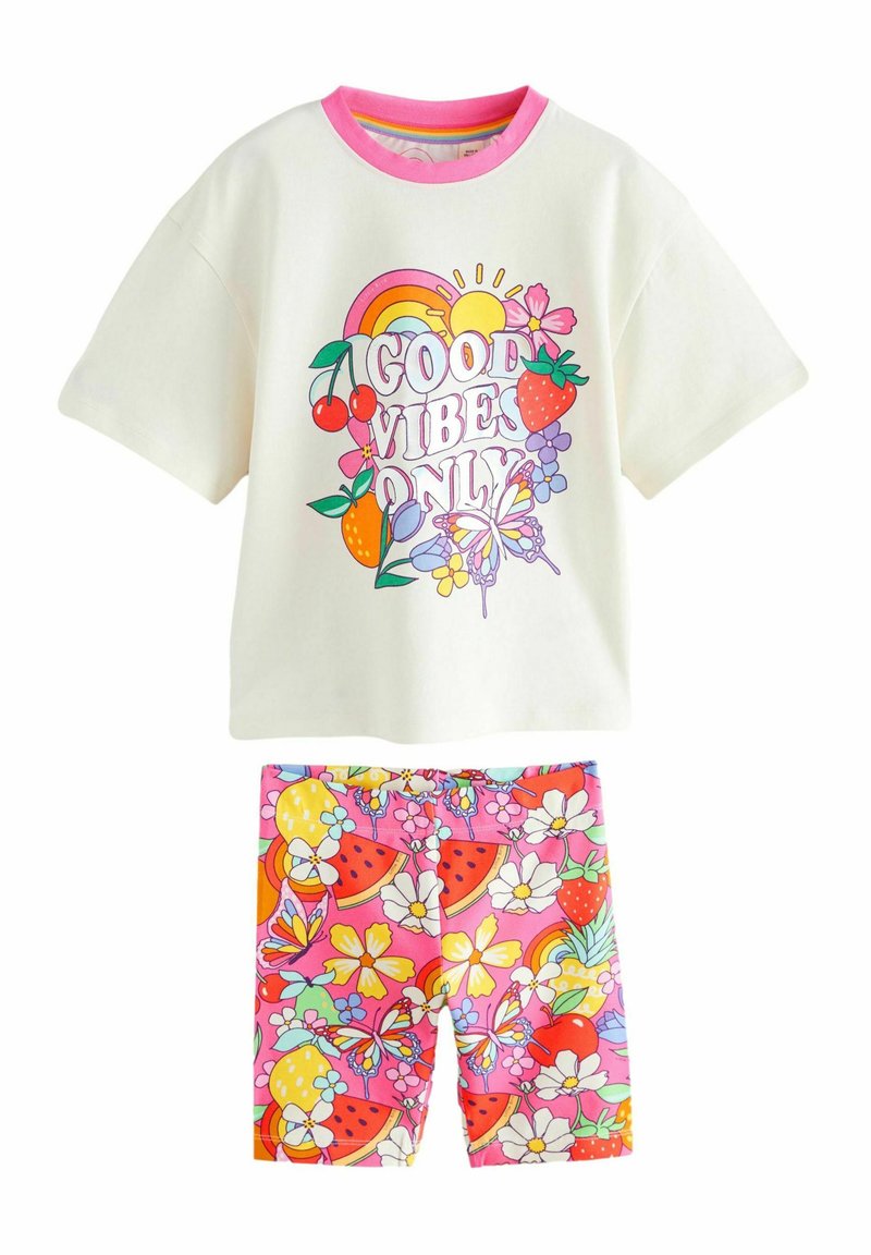Vit bomullströja med rosa krage som har en färgglad "Good Vibes Only" grafik; matchande rosa shorts med frukt- och blommönster.