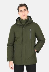 Giacca isolante verde con cappuccio, tasche con cerniera e interni testurizzati. Design aderente con chiusura a scatto frontale.
