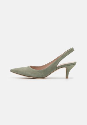 Zapato de tacón tipo slingback de ante verde con puntera puntiaguda y tacón fino. Textura suave y forro interior beige. Presenta un diseño minimalista.