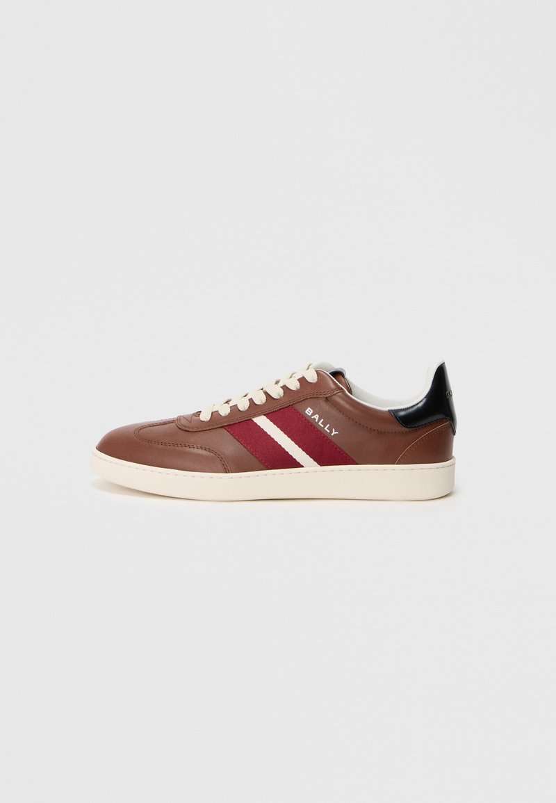 Barna bőr sneaker fehér és burgundi csíkokkal, bézs fűzőkkel és fekete sarok díszítéssel. Gumi talppal és sima felszíni textúrával rendelkezik.