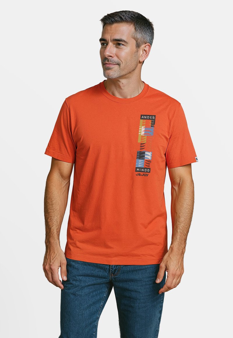 Oranje katoenen T-shirt met een grafische print met strepen en blokkleuren aan de linkerkant. Ronde hals en korte mouwen.