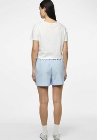 Vit kortärmad t-shirt och ljusblå randiga shorts, av bomullstyg, elastisk midja, och silverfärgade skor med vita strumpor.