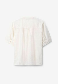 White short-sleeve blouse with embroidered floral patterns, textured fabric, and a relaxed fit. Features a gathered back detail.