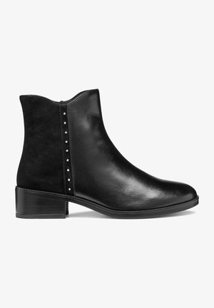 Zwarte enkelboot gemaakt van soepel leer met een suede paneel. Heeft decoratieve zilveren studs langs de zijkant en een lage, gestapelde hak.