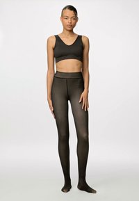 Top cropped preto e leggings de cintura alta em material transparente e elástico, apresentando um design sem costuras e uma silhueta justa.