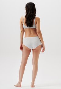 Ensemble en coton gris comprenant un soutien-gorge et un short taille haute, avec une texture lisse et un design minimaliste, des bretelles réglables et sans motifs supplémentaires.