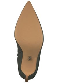 Scarpa a punta con tomaia verde liscia e suola in gomma beige. Presenta un piccolo accento metallico sul tacco e una soletta testurizzata.