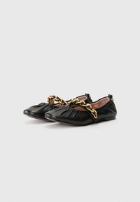Black leather flat shoes with a gathered design and a gold chain accent across the instep. Features a soft inner lining and flat sole.