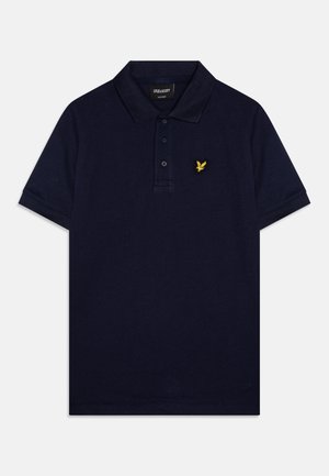 Marinblå bomullspiké med treknäppning, kort ärm och en broderad logotyp i gult på vänster bröst. Slät textur.