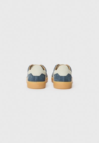 Blå og beige semsket sneakers med gummisåle. Baksiden har et distinkt bølgedesign og perforerte detaljer.