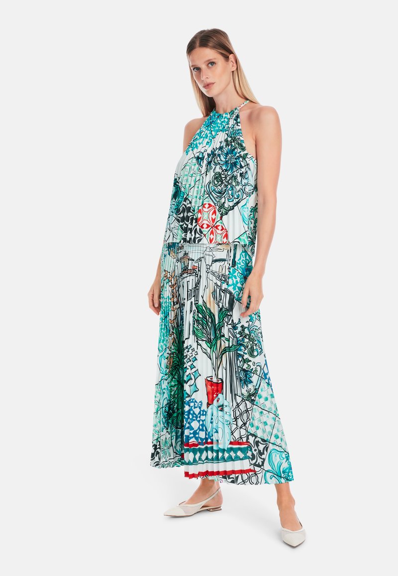 Halter-neck, sleeveless maxi dress in blue, green, and red patterns featuring floral and geometric designs, with a flowing fabric.