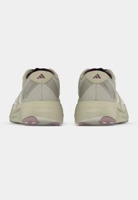 Αθλητικά παπούτσια σε ανοιχτό μπεζ χρώμα με υφασμάτινο πάνω μέρος με υφή, ενισχυμένα σημεία σε πιο σκούρες αποχρώσεις και μαλακή, ανοιχτόχρωμη σόλα.