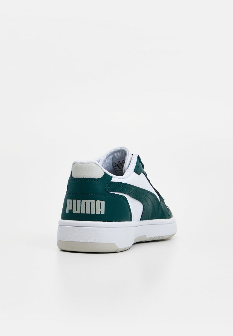 Zapatilla verde y blanca con textura de cuero, con cuello acolchado, forro de tela y un prominente logo blanco "PUMA" en el talón.