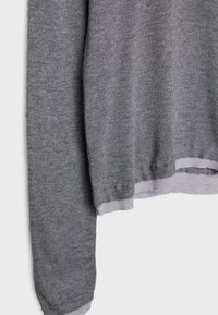 Grauer Pullover mit langen Ärmeln, der eine glatte Textur aufweist und hellgraue Rippbündchen sowie einen Rippabschluss hat. Das Material wirkt weich und leicht.