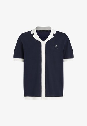 Granatowy sweter rozpinany na krótki rękaw z białym kołnierzykiem i plisą, z logo marki na piersi; gładka faktura i zapięcie na guziki.