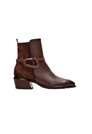 Stivaletto marrone con una combinazione di pelle texturizzata e camoscio, un accento metallico intrecciato alla caviglia e un tacco impilato.