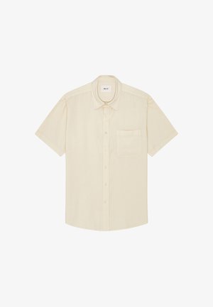 Beige kortærmet skjorte med knapper, brystlomme og klassisk krave, lagt fladt på en hvid baggrund.