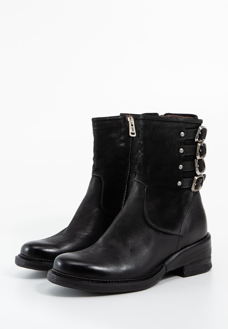 Bottes à cheville en cuir noir avec une finition texturée, une fermeture éclair sur le côté et des accents de sangle décoratifs avec des accessoires en métal argenté. Design à talon carré.