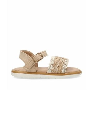 Sandalia beige con parte superior trenzada y correa ajustable en el tobillo. Plantilla acolchada y suela de goma blanca, con un diseño plano.