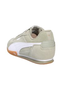 Zapatilla de ante verde claro con acentos de cuero blanco, suela de goma y talón texturizado. Presenta un acabado con costuras y un logo en el lateral.
