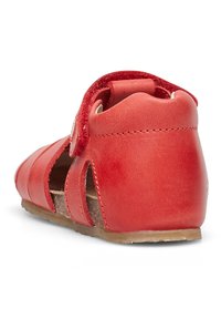 Sandal in pelle rossa con ritagli e chiusura con cinturino regolabile. Presenta una suola piatta e una finitura testurizzata. La vista posteriore mostra un design del tallone curvato.