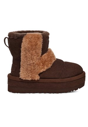 Bottine en daim marron avec semelle épaisse en mousse et rabat en shearling beige couvrant l'avant et les côtés sur fond blanc.