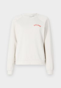 Sudadera blanca con mangas raglán, que presenta un texto curvado "STUDIO" en color naranja. Confeccionada en una tela suave, con puños y dobladillo acanalados.