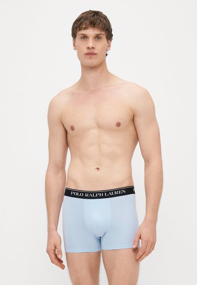 Svetlomodré boxerky s čiernym pásom, na ktorom je bielym textom nápis "POLO RALPH LAUREN". Vyrobené z hladkého, elastického materiálu.