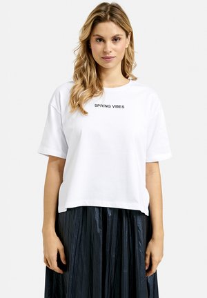 Weißes Baumwoll-T-Shirt mit kurzen Ärmeln, das den Schriftzug "SPRING VIBES" in Schwarz trägt. Hat eine lässige Passform und einen verkürzten Saum.
