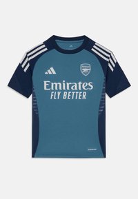 Blue sports jersey with short sleeves, featuring white accents, a crew neck, and a logo. Made from breathable fabric with a textured finish.