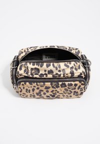 Bolso de mano de tela con estampado de leopardo, con dos compartimentos con cremallera, bordes redondeados, herrajes plateados y un logotipo prominente en el interior.