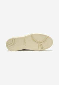 Sole della scarpa in bianco sporco con un motivo a zigzag testurizzato, caratterizzata da ritagli circolari e dal logo impresso "GHOUD" sul lato.