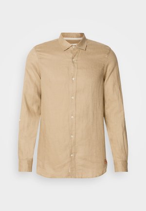 Helle beige Langarmbluse aus Leinen, mit einer durchgehenden Knopfleiste, weicher Textur und Kragen. Mit einer Rolltab-Ärmeldetail.