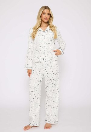 White pajama set with navy star patterns, contrasting trim, long sleeves, button-down top, and straight-leg pants. Soft fabric texture.