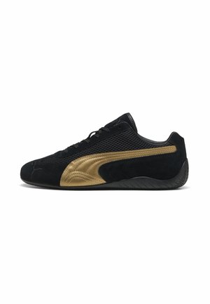 Svart mocka och mesh sneakers med en guldig accentrand, som har en låg profil, snörningsdesign och en texturerad gummisula.