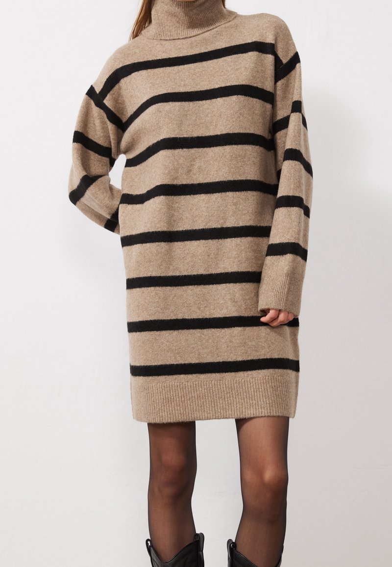 Robe-pull col roulé beige avec rayures horizontales noires, texture tricotée, poignets et ourlet côtelés, arrivant au-dessus du genou.