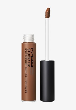 Tube de correcteur liquide étiqueté MAC Studio Fix 36HR Smooth Angles avec capuchon noir et applicateur, montrant une teinte marron moyen.